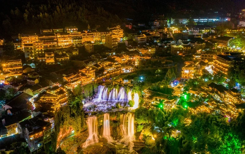 Spectacular night illumination of Furong Ancient Town stilt houses hanging over the cliffs